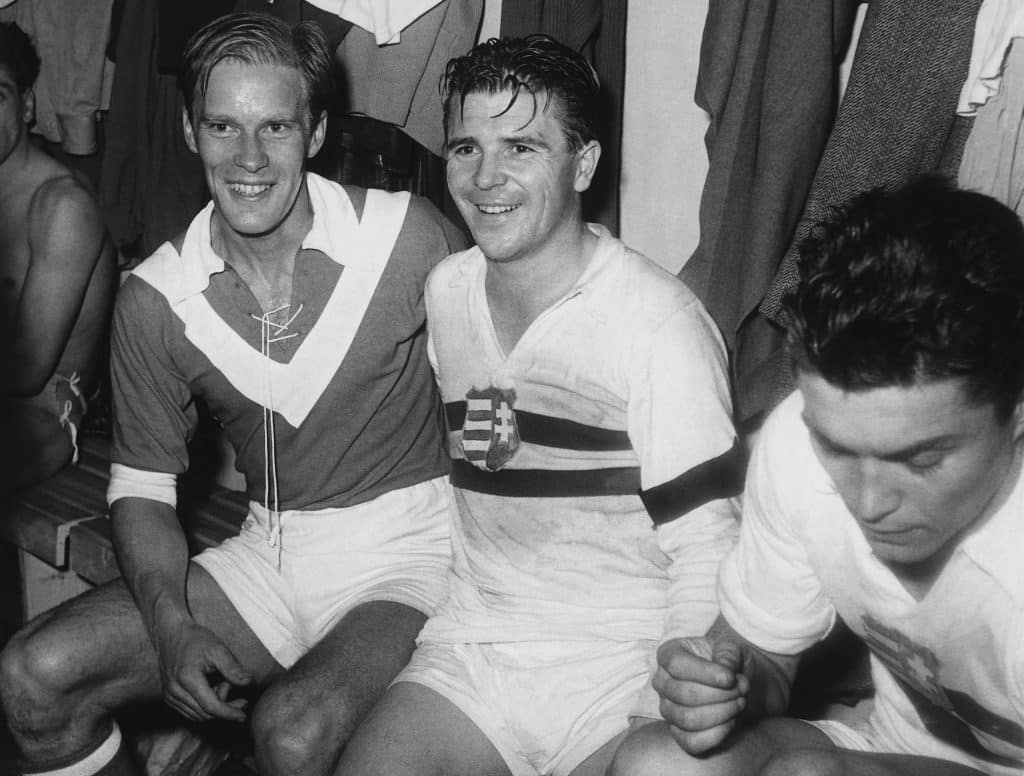 Ferenc Puskas (middle), Hungarian soccer legend, in the changing room on November 8th 1956 after a game next to Sweden's Eckner (l). Due to the suppression of a national uprising in his home country Puskas is wearing a mourning band on his left arm and instead of the Sovjet emblem the Kossuth coat of arms on his chest. The goalgetter was the team captain of Hungary's "Dream Team" during the 50s, until he fled into exile to Spain. After a two-year suspension he successfully played for Real Madrid, until he stopped playing for good in 1969. In the upcoming years Puskas dabbled in coaching - with much less success. After the Eastern Bloc collapse he returned to Hungary in 1992 with his wife Erzsebet and daughter Anniko. 1998 he was elected "Hungary's football player of the century". | usage worldwide 