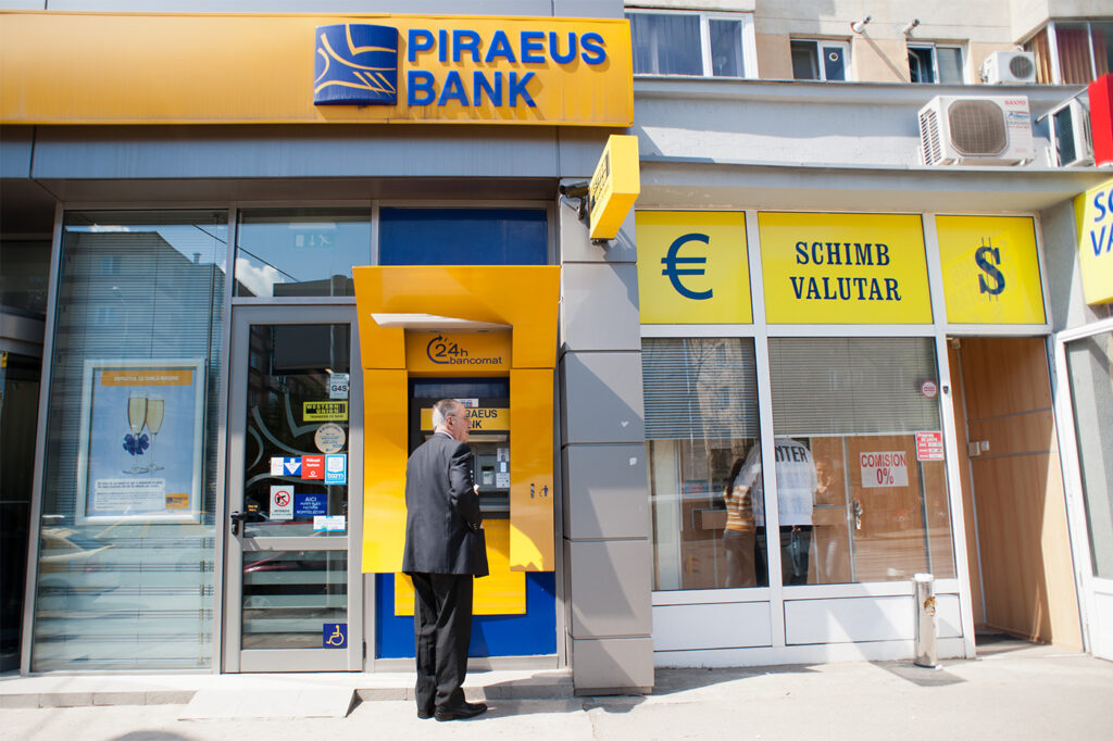 At Piraeus Bank, a Northeastern student spotted risk, turned a profit A man stands in front of a Piraeus Bank ATM.