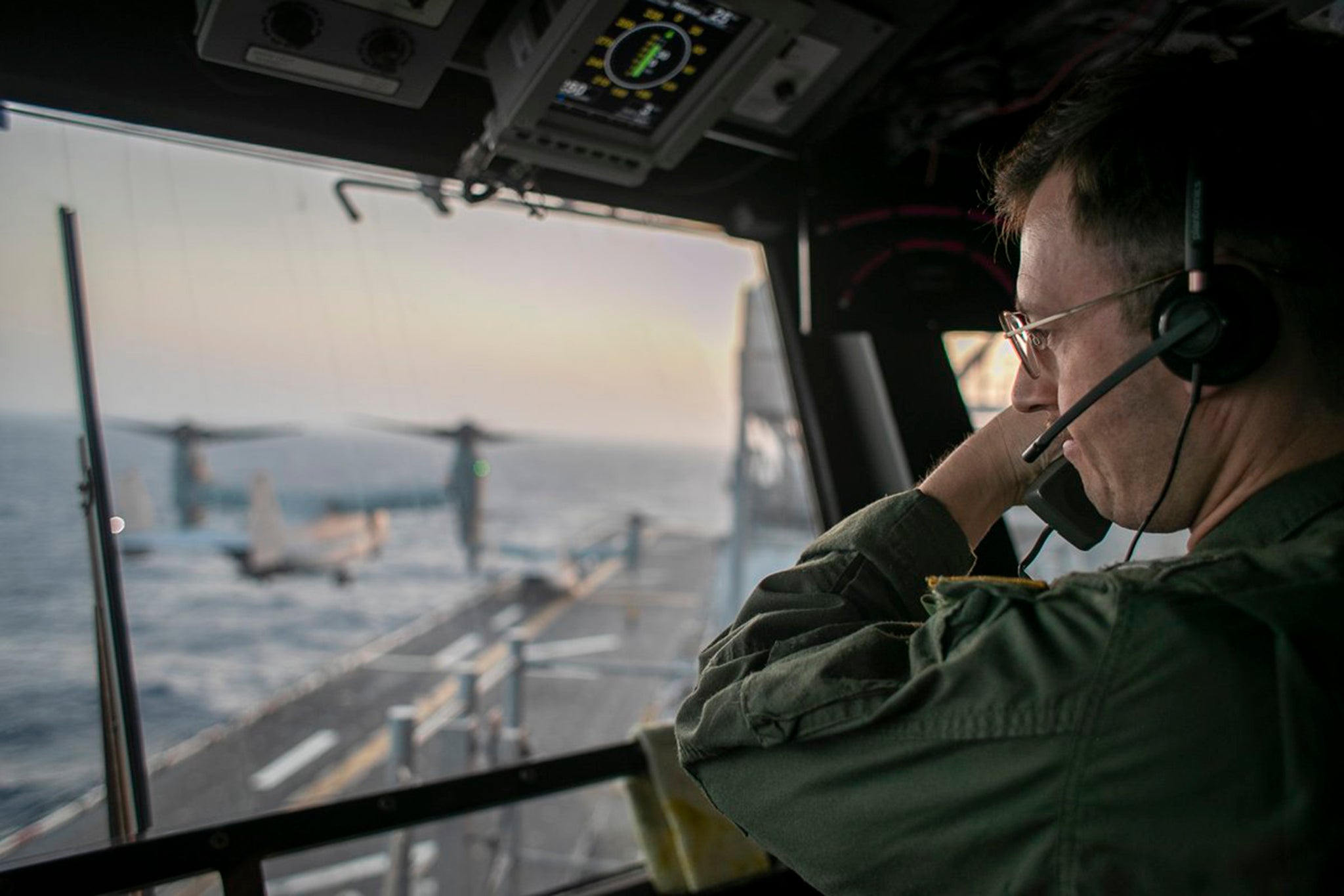 A naval officer aboard USS Tripoli (LHA 7) oversees enforcement of the naval blockade against Iran