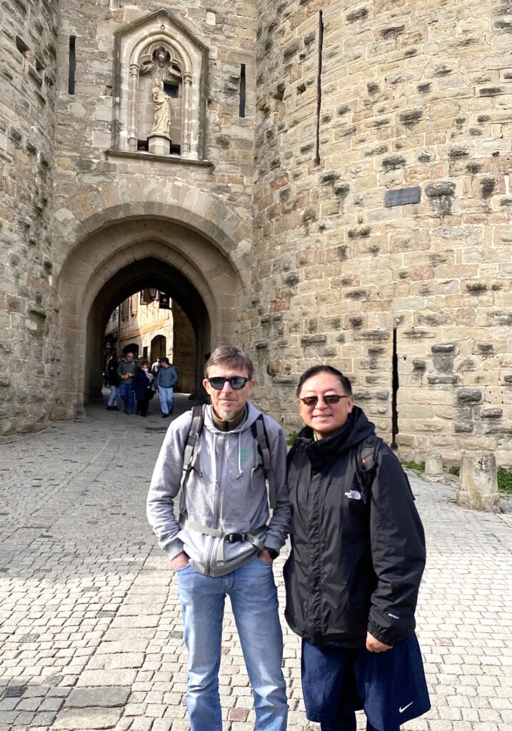Jean Marie Francois posing with Bin Yang in front of a citadel.