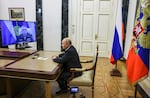 Russian Strategic Missile Forces chief, Col. Gen. Sergei Karakayev, left on the screen, reports to President Vladimir Putin on a successful test launch of the Sarmat intercontinental ballistic missile at the Kremlin in Moscow, Tuesday, May 12, 2026.