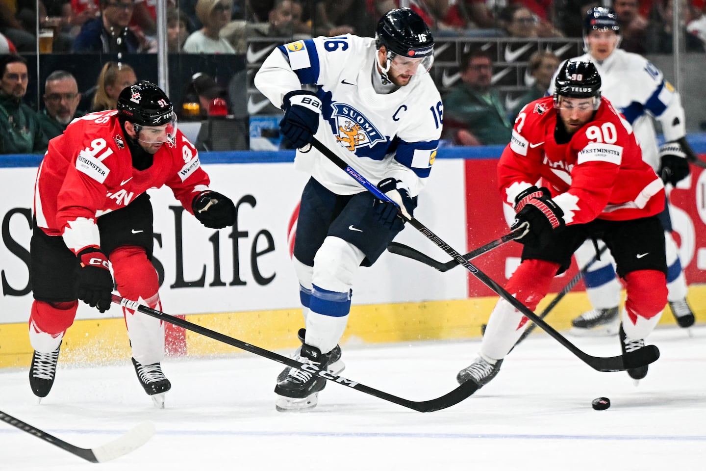 Finnish center Aleksander Barkov battles through stickchecks by Canada's Ryan O'Reilly (right) and John Tavares (left) during Saturday's IIHF Ice Hockey Men's World Championship semifinal in Zurich.