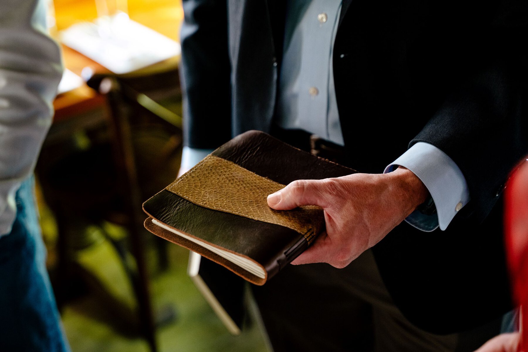 A man holds a leather notebook cover made from fish leather. 