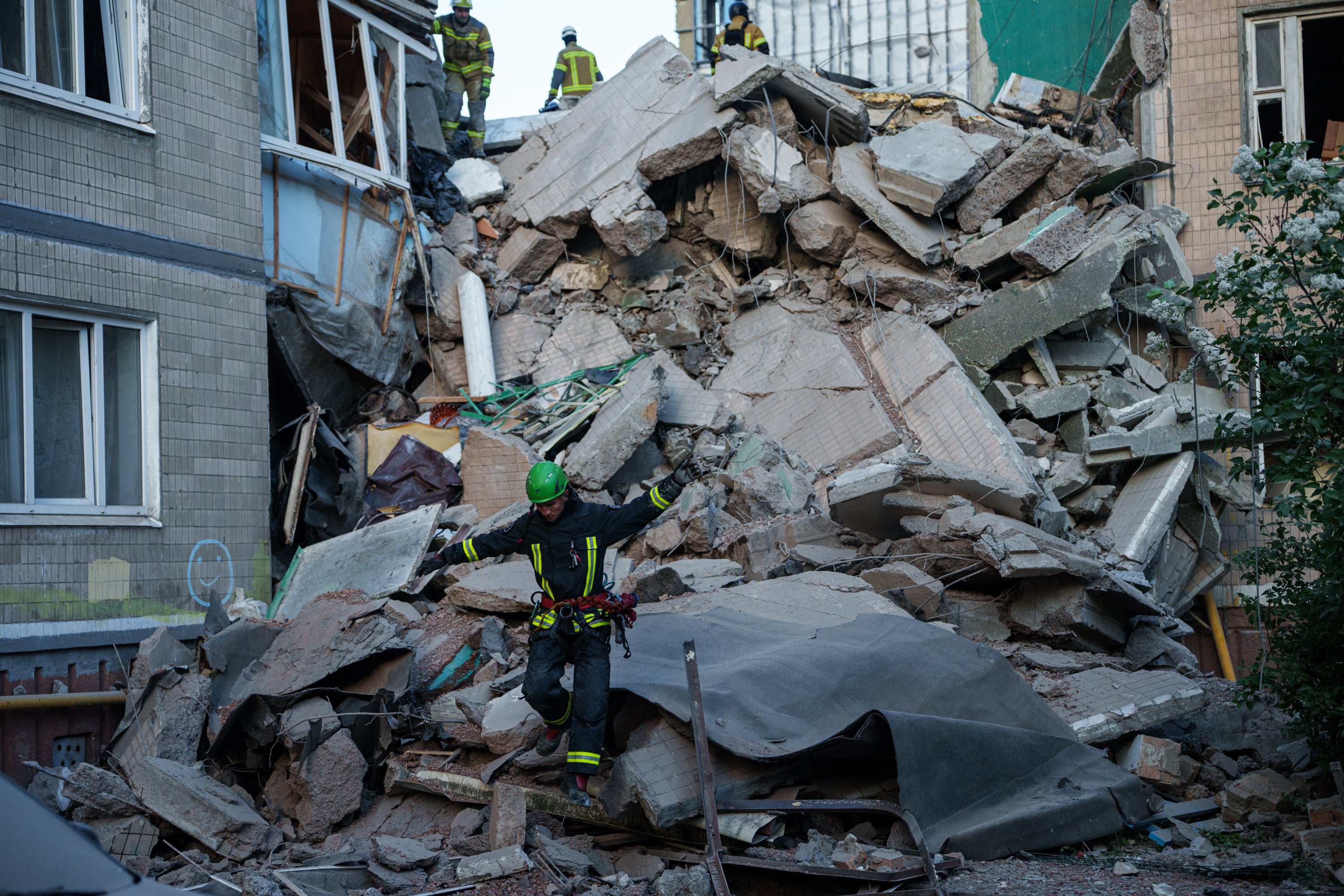 A rescue worker walks on the rubble of a house heavily damaged after a Russian strike on residential neighbourhood in Kyiv,