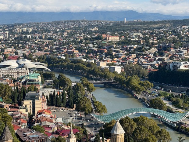 A turquoise river runs through an urban landscape