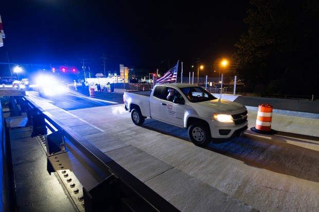 At approximately 3 a.m. on May 11, 2026, a U.S. Army Corps of Engineers vehicle carrying the Deep Creek Bridge Replacement Project manager and senior construction inspector crosses the new bridge span for the first time in Chesapeake, Virginia, as Chesapeake police officers follow, leading traffic through the new pattern during a major traffic shift entering Phase 5 of construction. The overnight operation marked the first time vehicles traveled across the new bridge span since construction began.