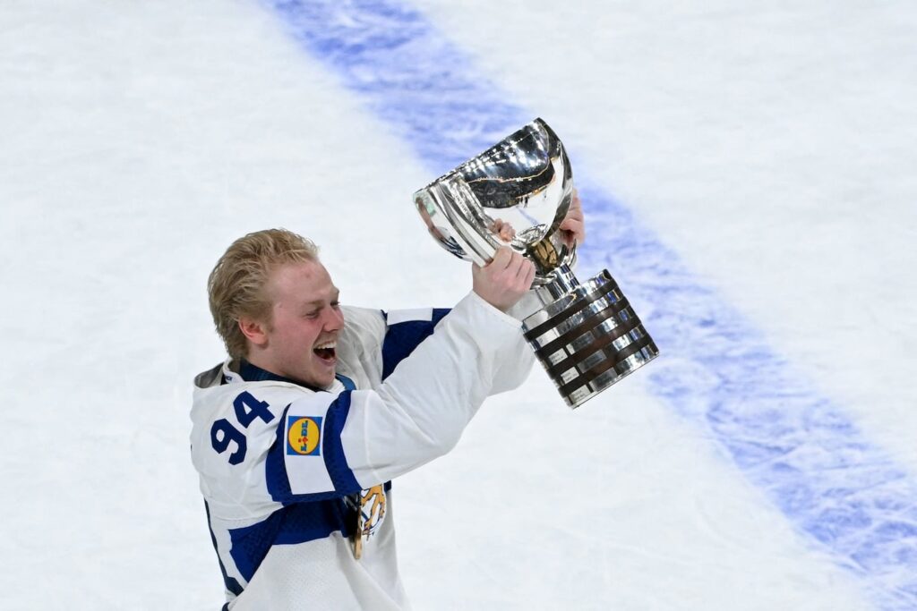 Konsta Helenius carries the trophy after his overtime goal helped Finland beat Switzerland on Sunday.