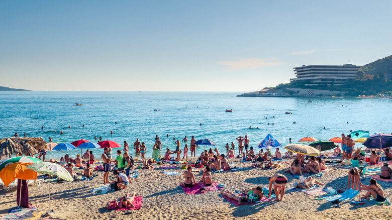 People on a crowded beach basking in the sun
