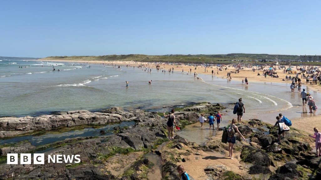 Weather: Temperatures could surpass May record in Ireland A beach on a sunny day. It is filled with people but their faces are not clear in the image.