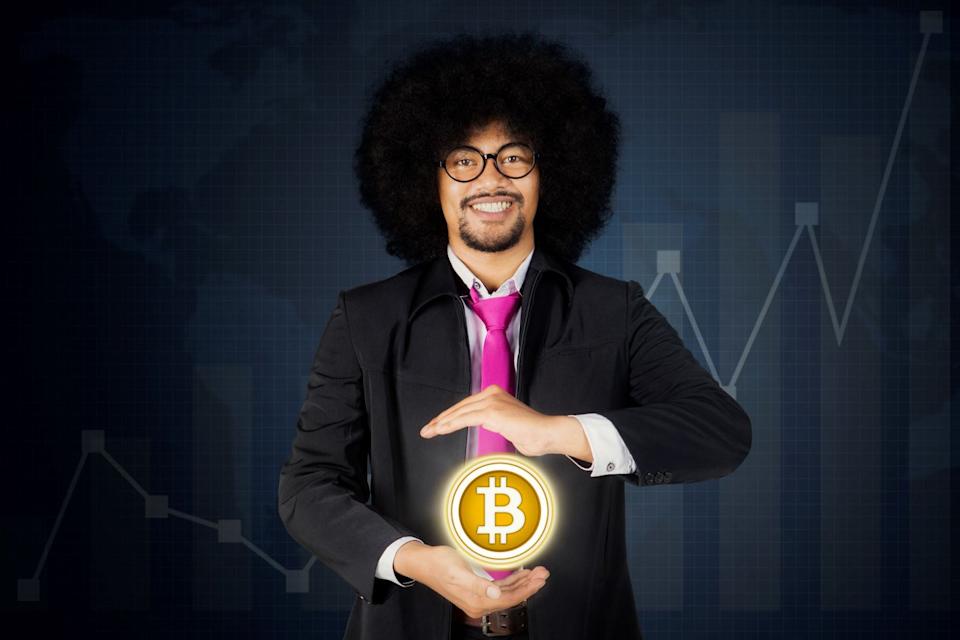 Person in a suit with an image of Bitcoin in front of them.