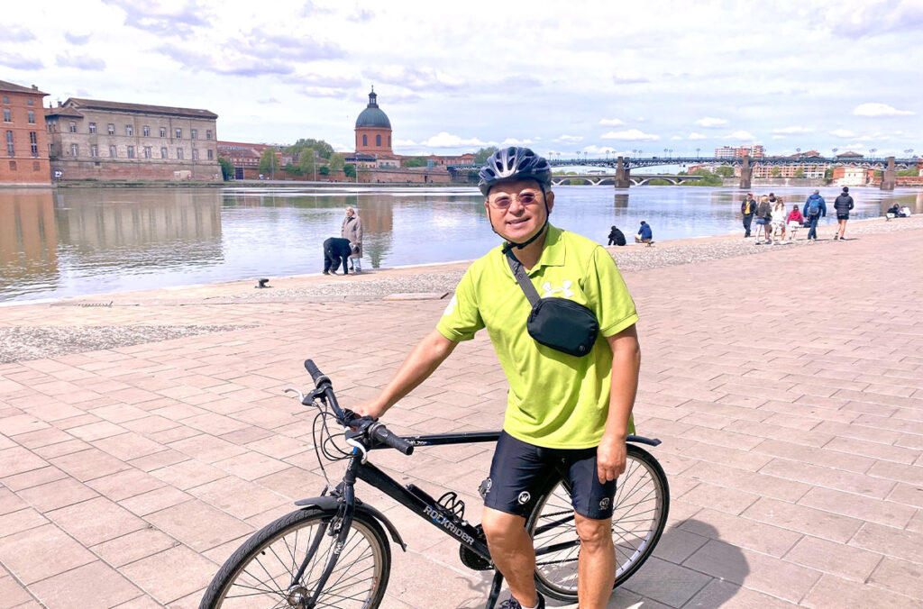 Fulbright France highlights WSU professor’s global energy impact for America’s 250th | WSU Insider Bin Yang poses next to his bicycle in front of a waterway in Toulouse, France.