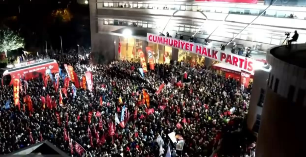 Özgür Özel is making a statement in front of CHP Headquarters. His statement is interrupted by slogans of 'Traitor Kemal'.