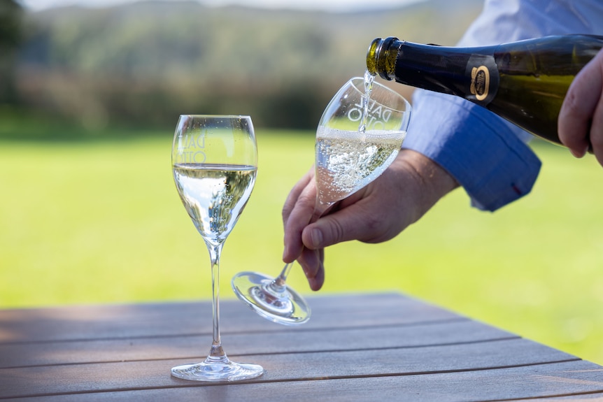 Someone pours a glass of prosecco