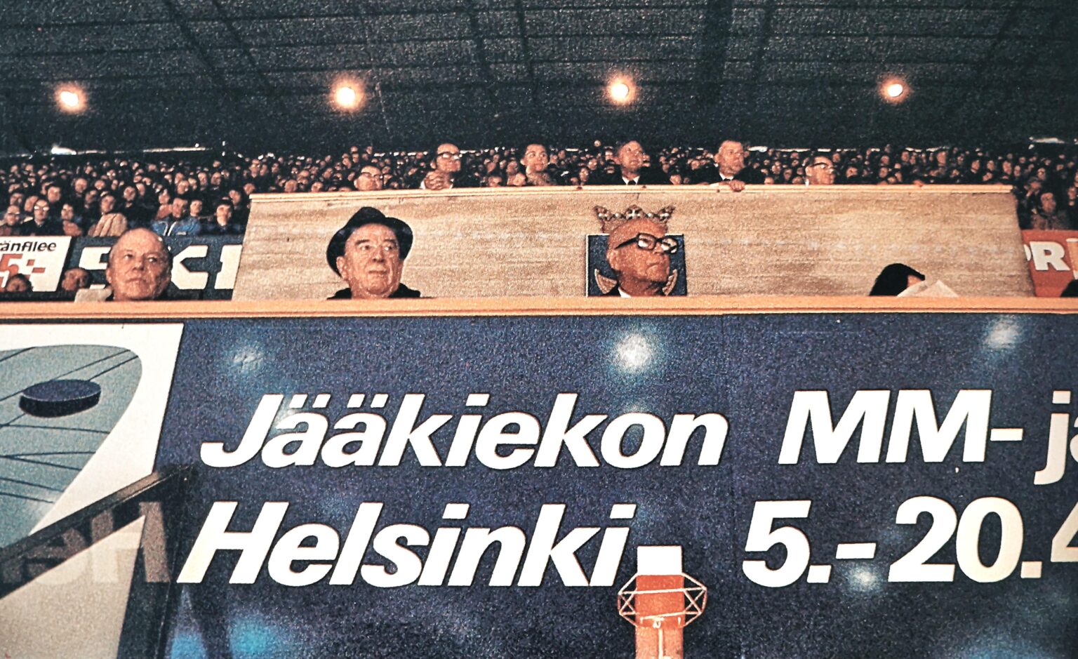God of Finland Urho Kaleva Kekkonen (bald, with mighty glasses) watching ice hockey's world championship's in Helsinki 1974. Photographer has chosen the right angle, behind his head is Helsinki's coat of arms and the crown