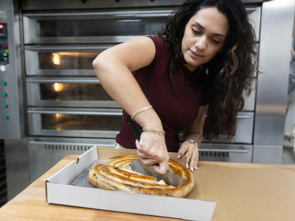  Aulona Duraj cuts a burek, a traditional Balkan meat pie.