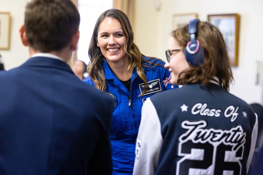 An astronaut talking to high school students at a civic reception.