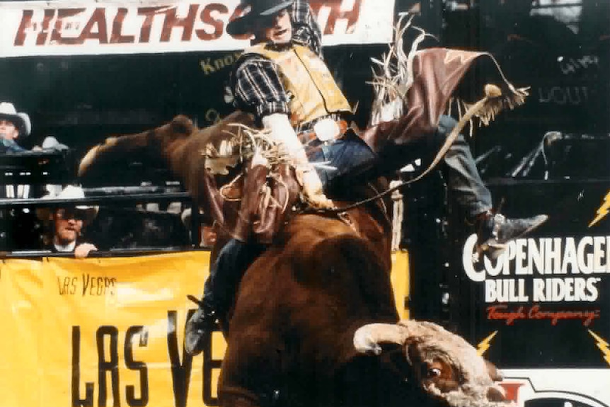 Troy Dunn riding a large bucking bull. 