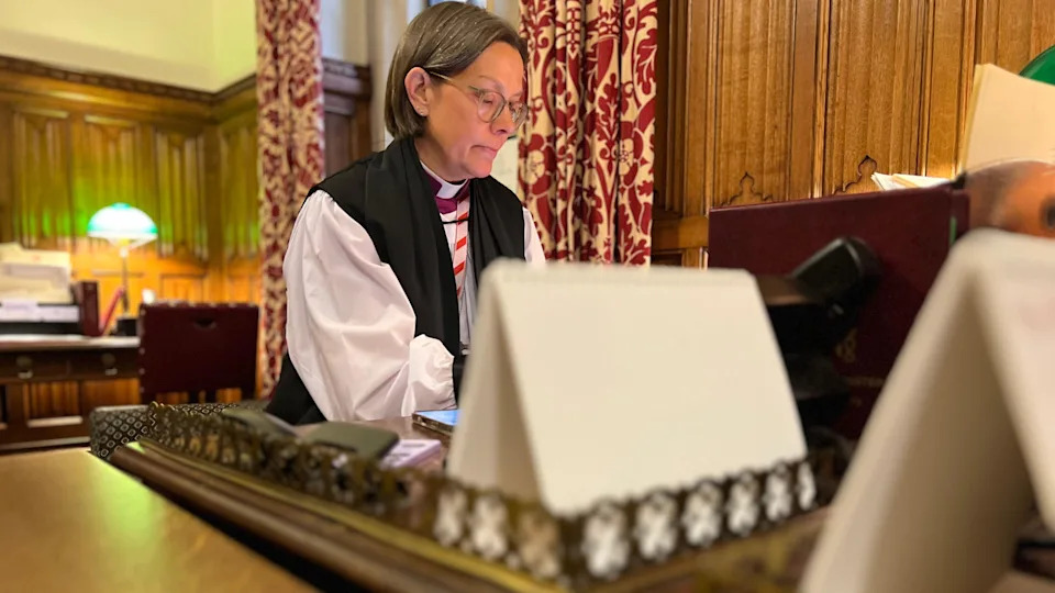 Bishop of Newcastle Helen Ann Hartley sits at her desk in Westminster, wearing her clergy clothing.