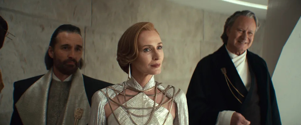 Three actors in a futuristic setting, wearing elaborate sci-fi costumes with intricate geometric designs