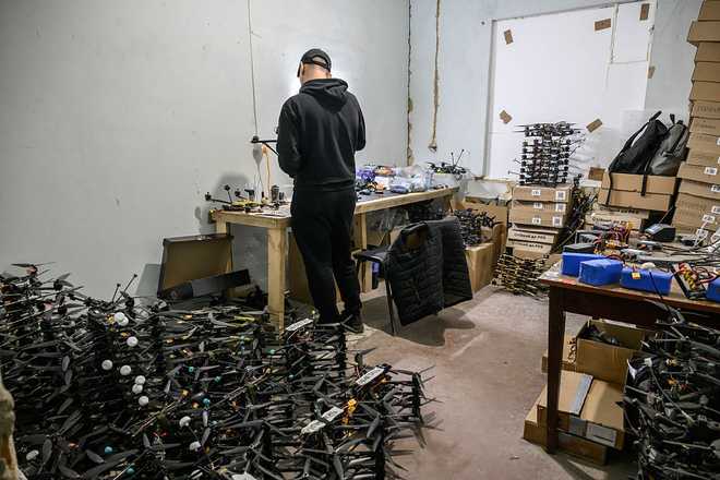 TOPSHOT - A technician works on drones at a workshop at an undisclosed location in Ukraine on October 7, 2025, amid the Russian invasion of Ukraine. (Photo by Ed JONES / AFP via Getty Images)