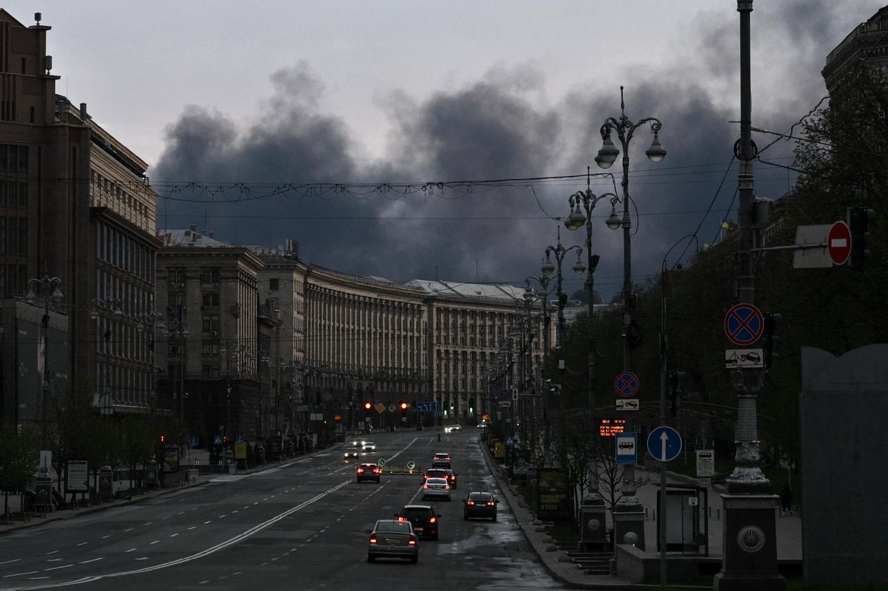 Cars drive along Khreshchatyk Street as smoke rises above buildings in the background following an air attack in Kyiv on April 16, 2026, amid the Russian invasion of Ukraine. (AFP Photo)