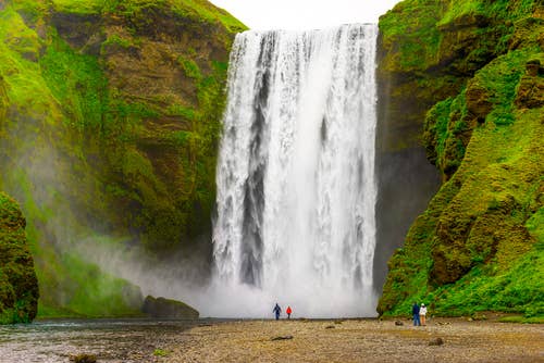Skogafoss Waterfall with visitors standing at the base, a must-see on the South Coast of Iceland in April. Skogafoss Waterfall with visitors standing at the base, a must-see on the South Coast of Iceland in April.