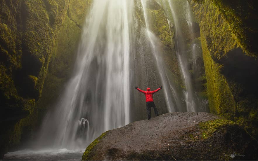 Traveler standing inside Gljufrabui Waterfall cave with mossy walls, a hidden gem to explore in Iceland in April. Traveler standing inside Gljufrabui Waterfall cave with mossy walls, a hidden gem to explore in Iceland in April.