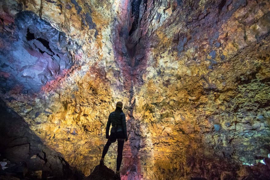 Traveler inside the lit magma chamber of a volcano, a unique adventure in Iceland in April. Traveler inside the lit magma chamber of a volcano, a unique adventure in Iceland in April.