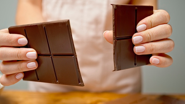 woman breaking chocolate bar