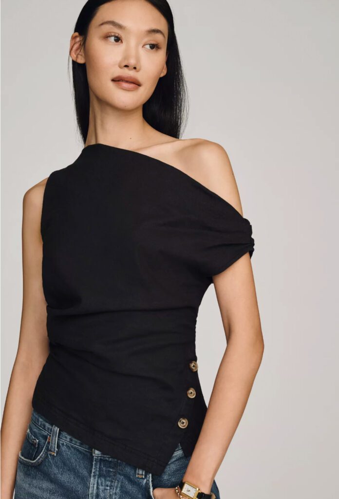 Black asymmetric off-shoulder top with gold button details and ruched waist, styled with denim jeans – chic summer outfit for Croatia vacation