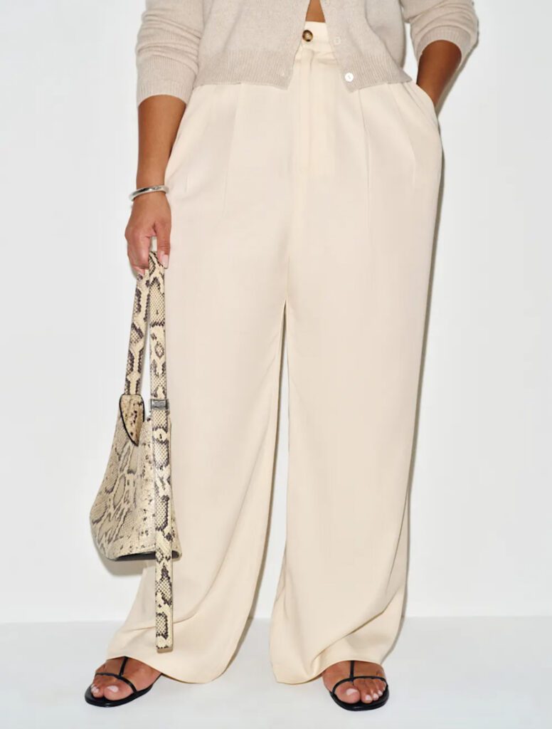 Cream wide-leg pleated trousers styled with a beige cardigan and snake-print bag – elegant summer pants outfit for Croatia vacation