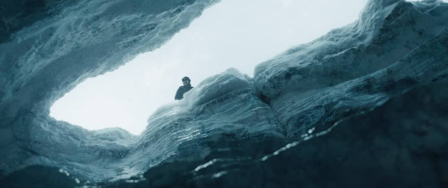 Person standing in deep glacier crevasse in Iceland in Mickey 17 film scene. Person standing in deep glacier crevasse in Iceland in Mickey 17 film scene.