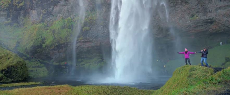 The couple at Seljalandsfoss waterfall on the south coast of Iceland The couple at Seljalandsfoss waterfall on the south coast of Iceland
