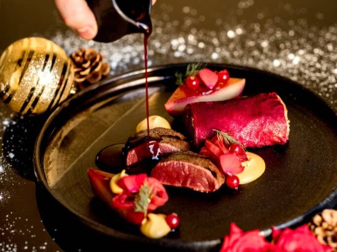 Gourmet holiday dinner at Kol restaurant in Reykjavik with seared meat, root vegetables, and sauce Gourmet holiday dinner at Kol restaurant in Reykjavik with seared meat, root vegetables, and sauce