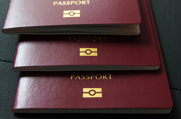 Close-up of stacked red passports with gold emblem and text on the covers.