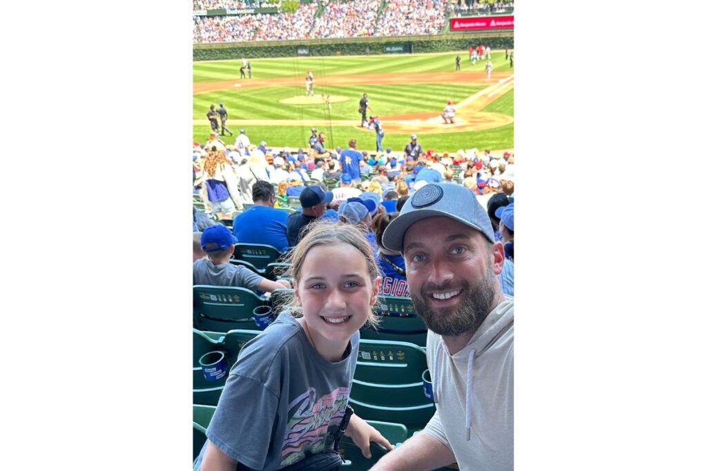 Patrick Ireland appointed new Director of Sales at Illini Media Group A man and a girl smiling at a baseball game from the stands, with the field and players visible in the background.