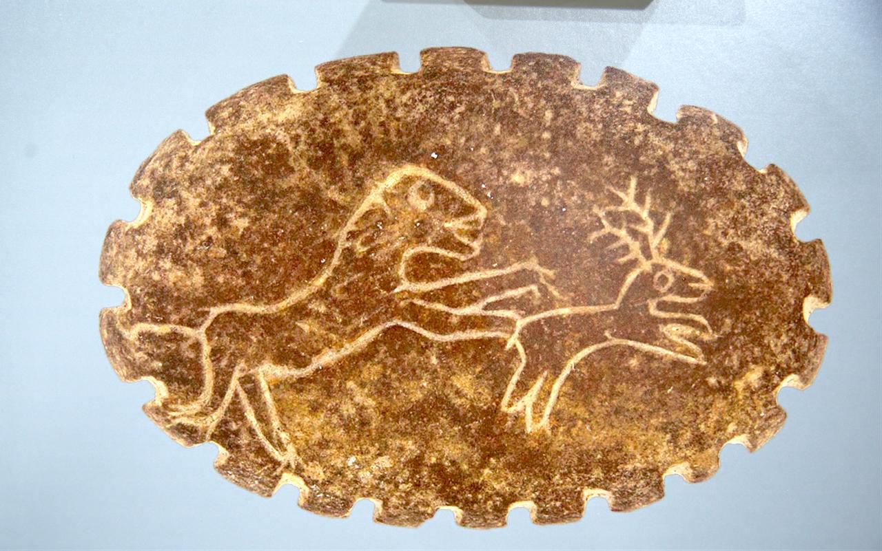 A close-up photograph shows an ancient seal motif with animal figures, displayed in the “Mesopotamian Breezes at the Summit of Anatolia” exhibition in Erzurum, Türkiye. (AA Photo)