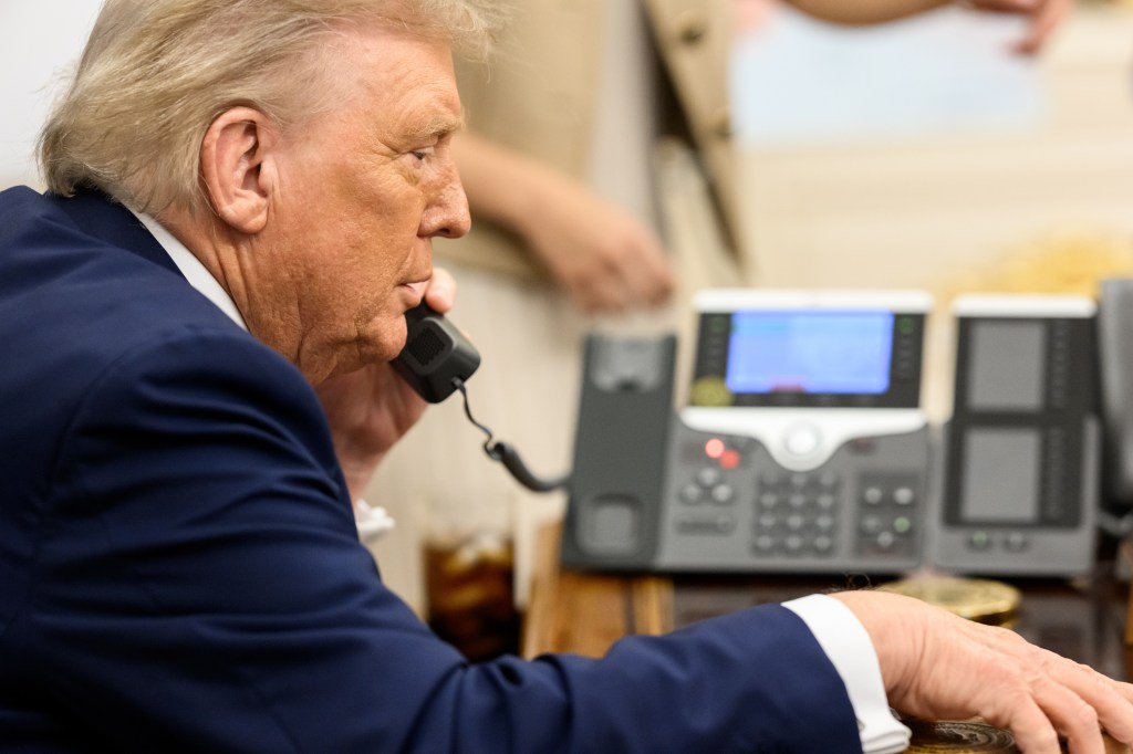 President Donald Trump speaking on the phone in the Oval Office.