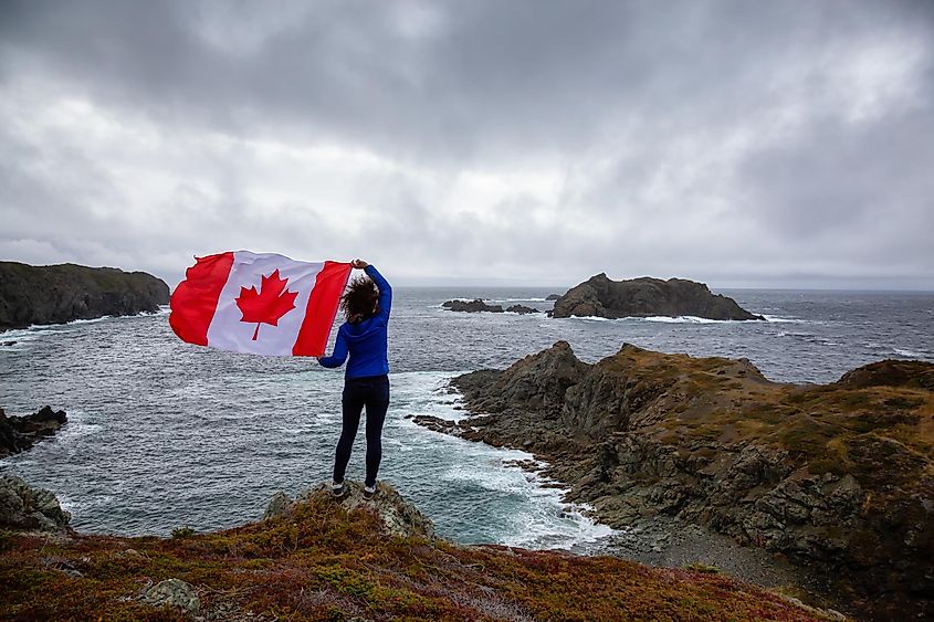 A woman holding a Canadian flag in Newfoundland.