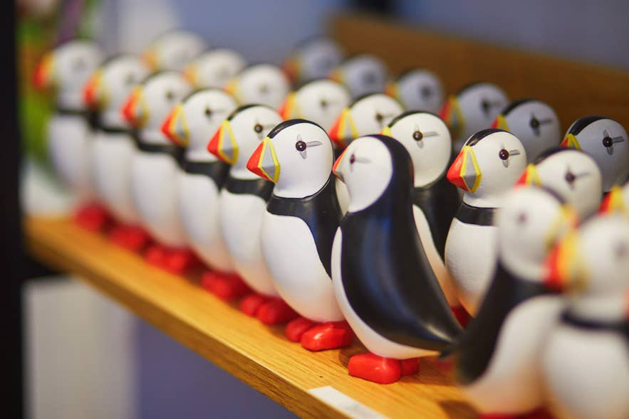 Row of wooden puffin souvenirs displayed on a shelf in an Iceland gift shop Row of wooden puffin souvenirs displayed on a shelf in an Iceland gift shop