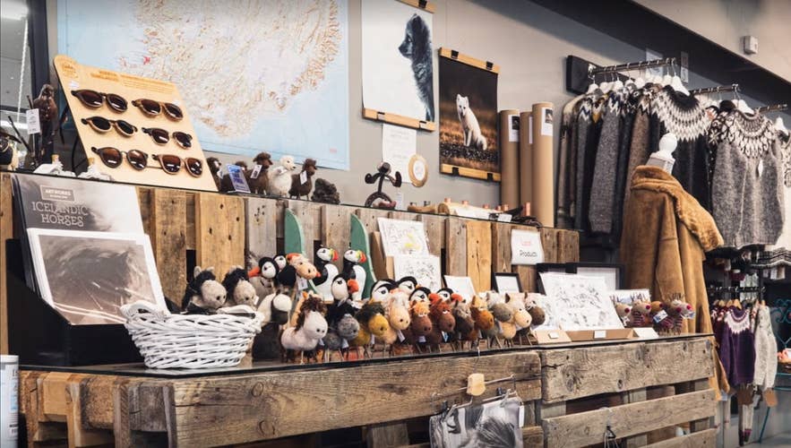 Display of Icelandic souvenirs at UNA Gift Shop, including lopapeysa sweaters and puffin toys Display of Icelandic souvenirs at UNA Gift Shop, including lopapeysa sweaters and puffin toys