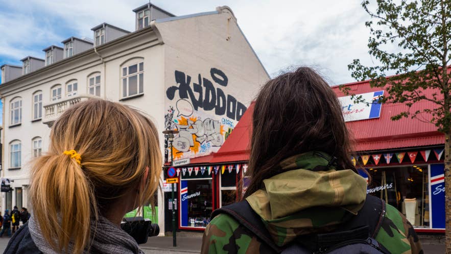 Travelers walking past souvenir shops and street art in downtown Reykjavik, Iceland Travelers walking past souvenir shops and street art in downtown Reykjavik, Iceland