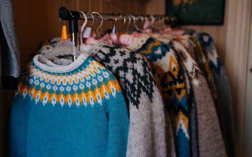 Handmade Icelandic wool sweaters with classic patterns hanging in a store Handmade Icelandic wool sweaters with classic patterns hanging in a store
