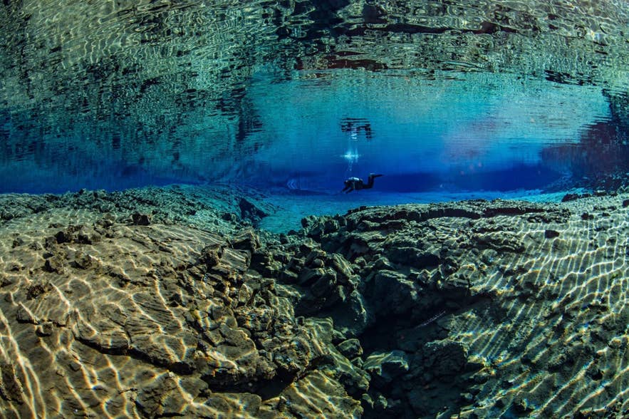 Diver exploring the crystal-clear waters of Silfra fissure in Iceland's Thingvellir National Park. Diver exploring the crystal-clear waters of Silfra fissure in Iceland's Thingvellir National Park.