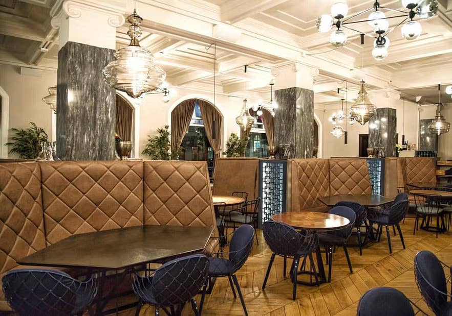 Apotek Restaurant in Reykjavik with plush seating, marble columns, and ambient lighting.