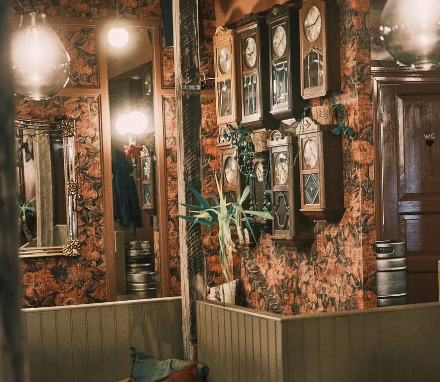 Elly Bar in Reykjavik with vintage clocks on patterned walls and eclectic decor accents.