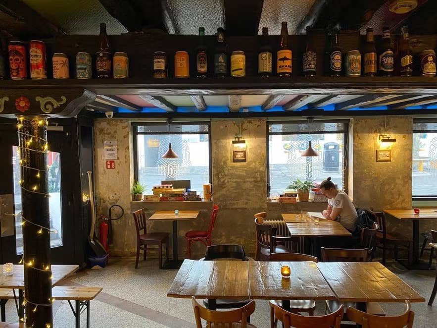 ÆGIR 101 taproom in downtown Reykjavik with rustic decor, wooden tables and Icelandic beer bottles displayed.