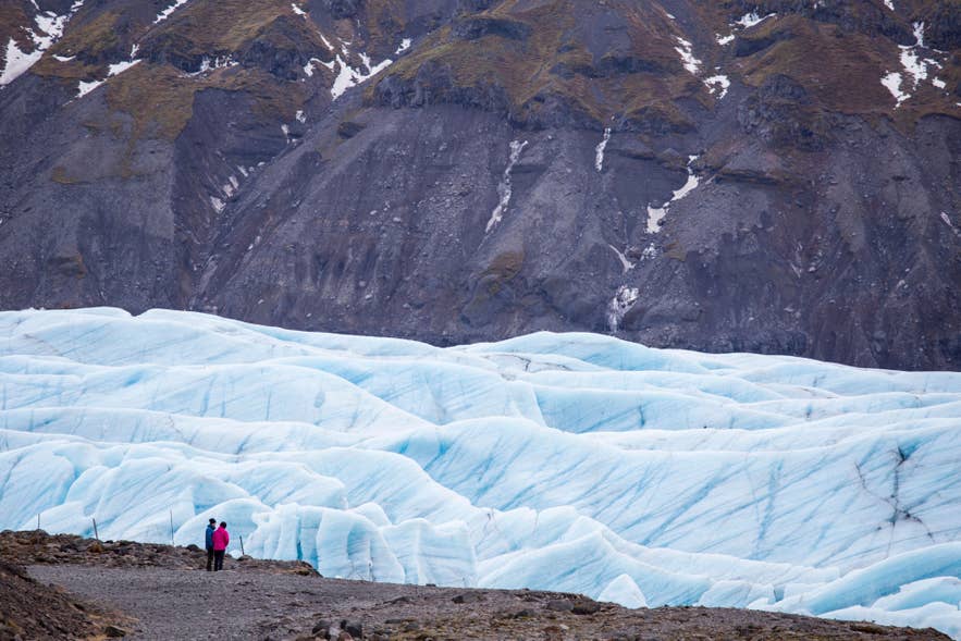 Wide view of Svinafellsjokull glacier with rugged mountains and bright blue ice