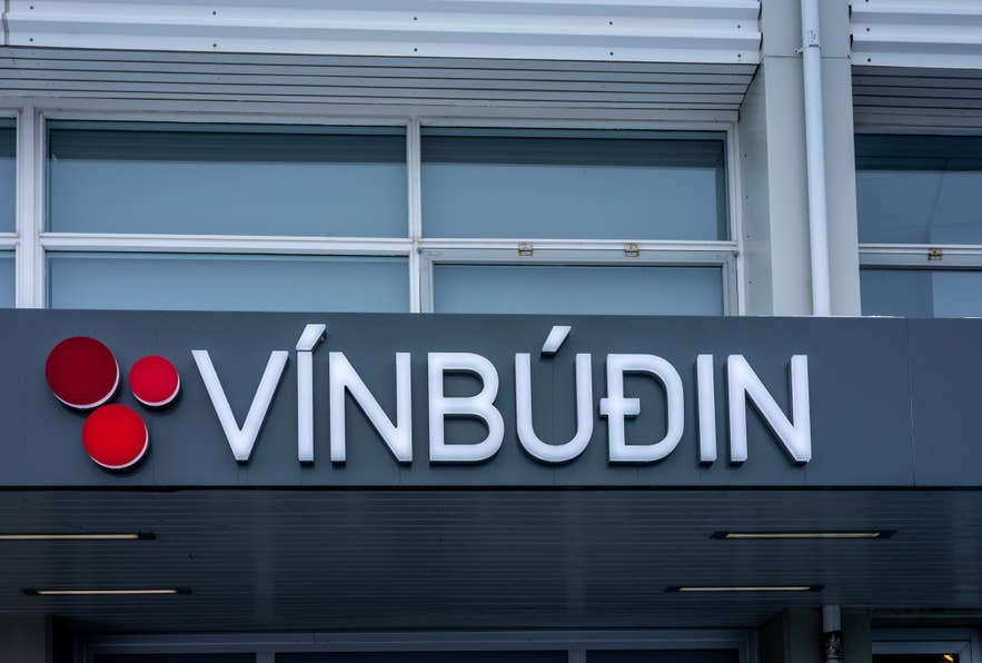 The illuminated Vinbudin sign on the exterior of a state-run liquor store in Iceland.