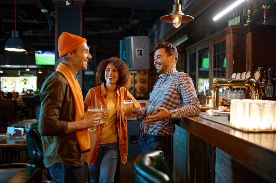 Friends chatting in a bar, reflecting how Iceland population is small and close-knit